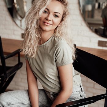 confident-blonde-woman-with-curly-hair-sitting-on-WLVMFKC.jpg